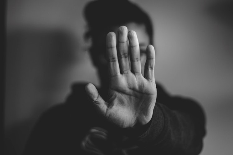 Kobieta wyciągająca dłoń w geście "stop"