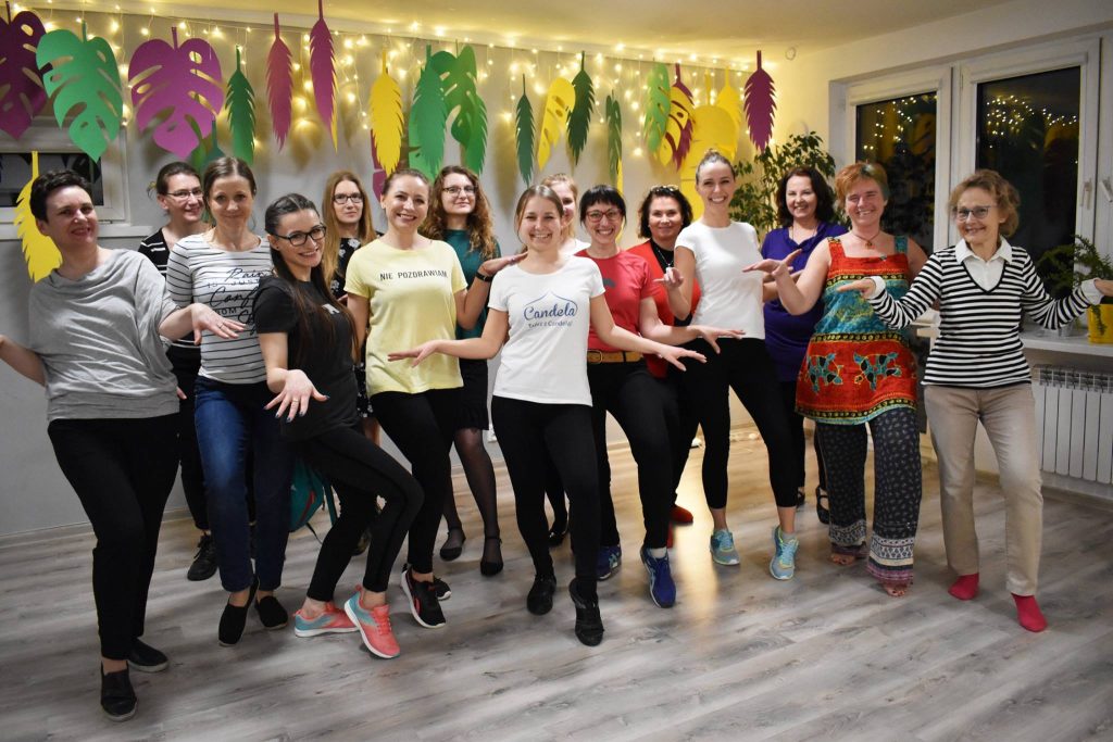 Piętnaście kobiet pozujących do zdjęcia na warsztatach tanecznych w MAL Samogłoska.
