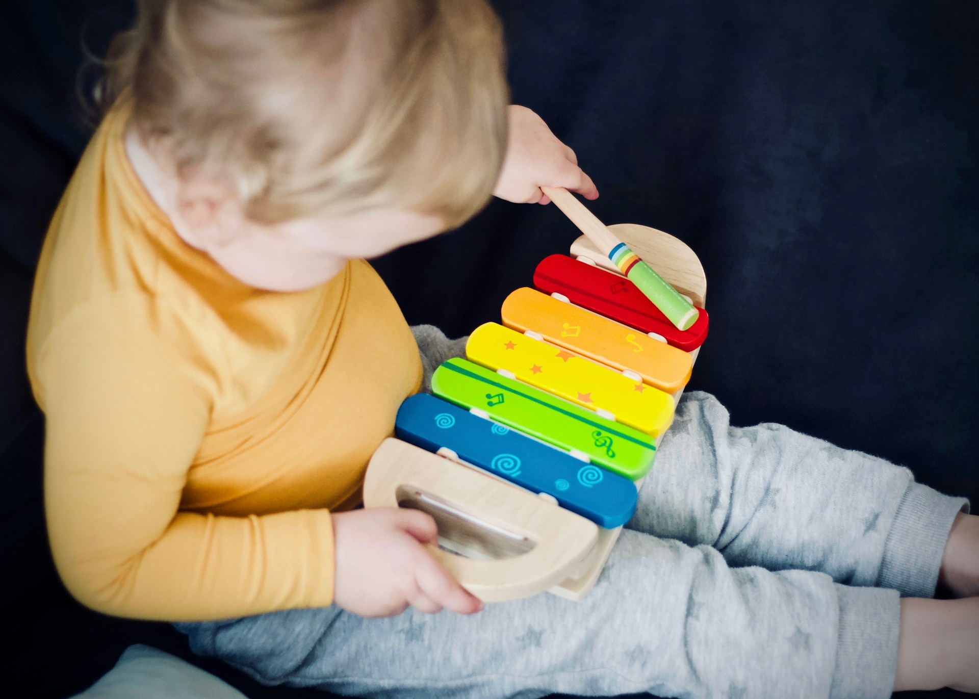 Dziecko gra na kolorowych cymbałkach.
