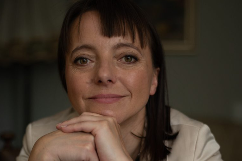 Kobieta w średnim wieku patrząca wprost do obiektywu.
