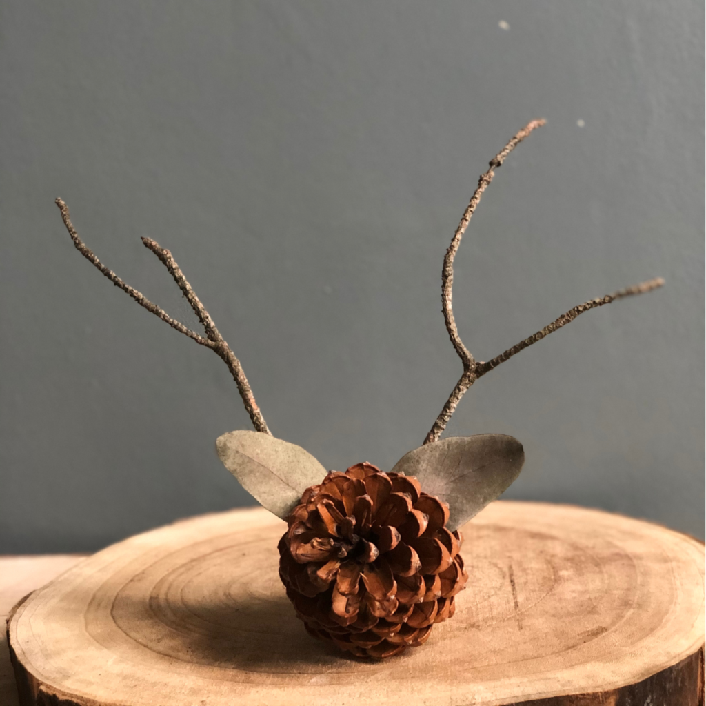 Ozdoba świąteczna wykonana z szyszki, patyczków i uschniętych liści.