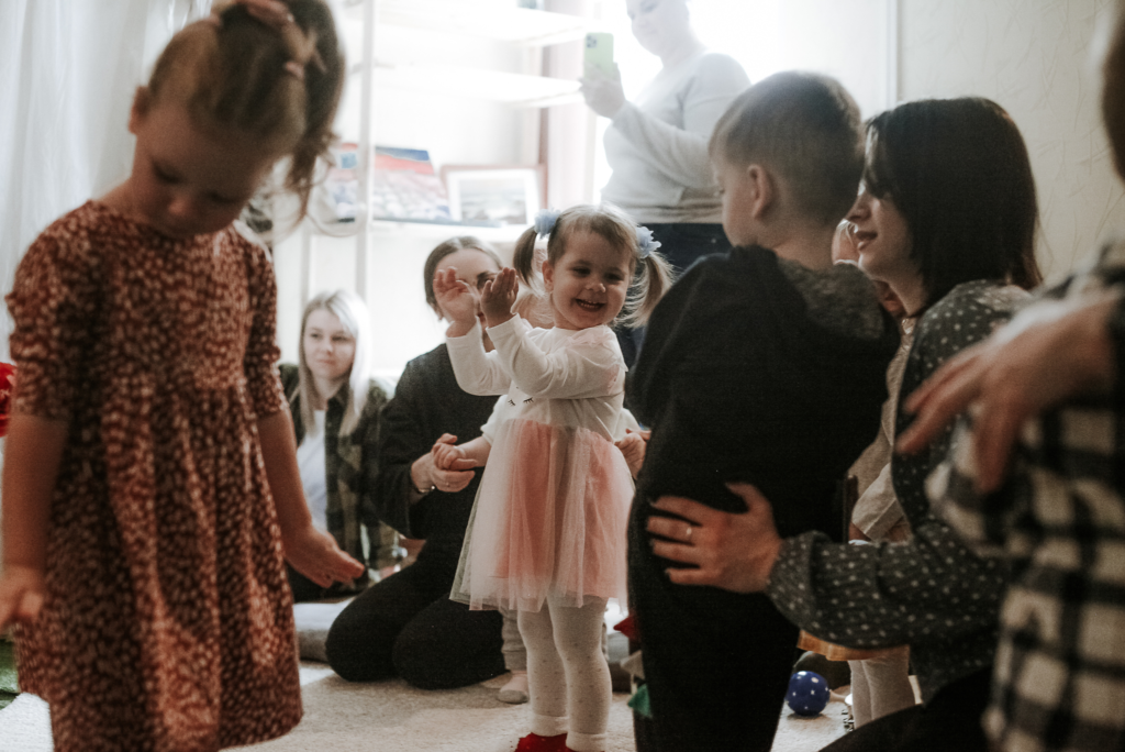 Dzieci bawiące się w sali razem z rodzicami.